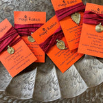wrist wraps by mayil with colorful silk strings and dokhra charms. Rakhi by MAYIL